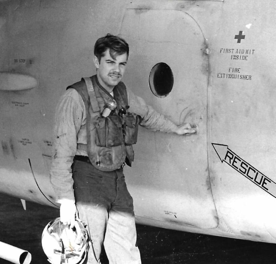 Craig A. Steele in flight gear standing beside an aircraft, helmet in hand
